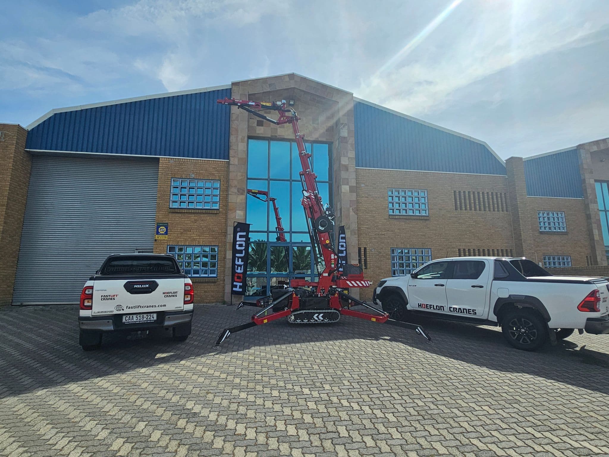 Hoeflon crane outside a building with two Fastlift Cranes vehicles.