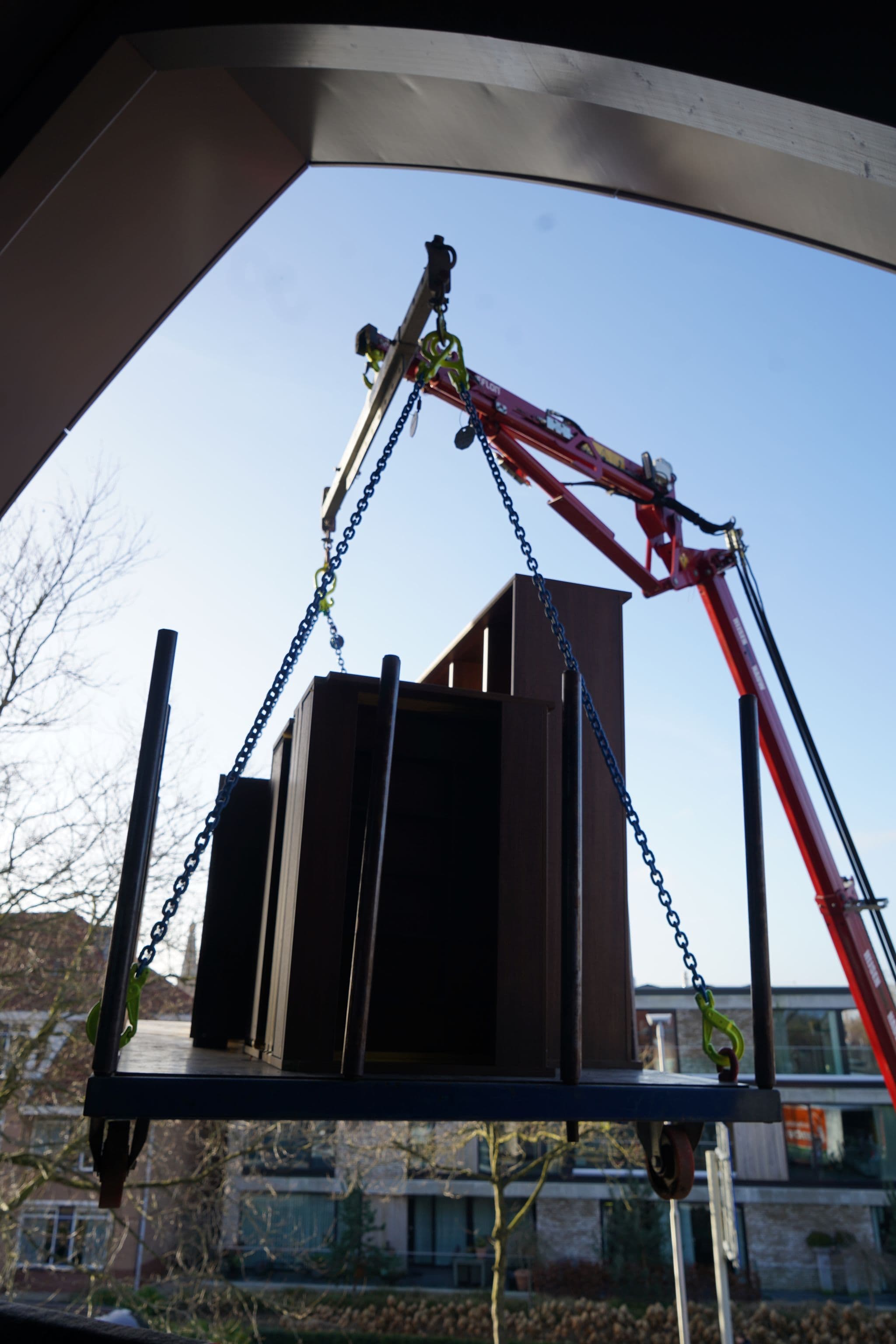 Hoeflon crane lifting an object with a chain.