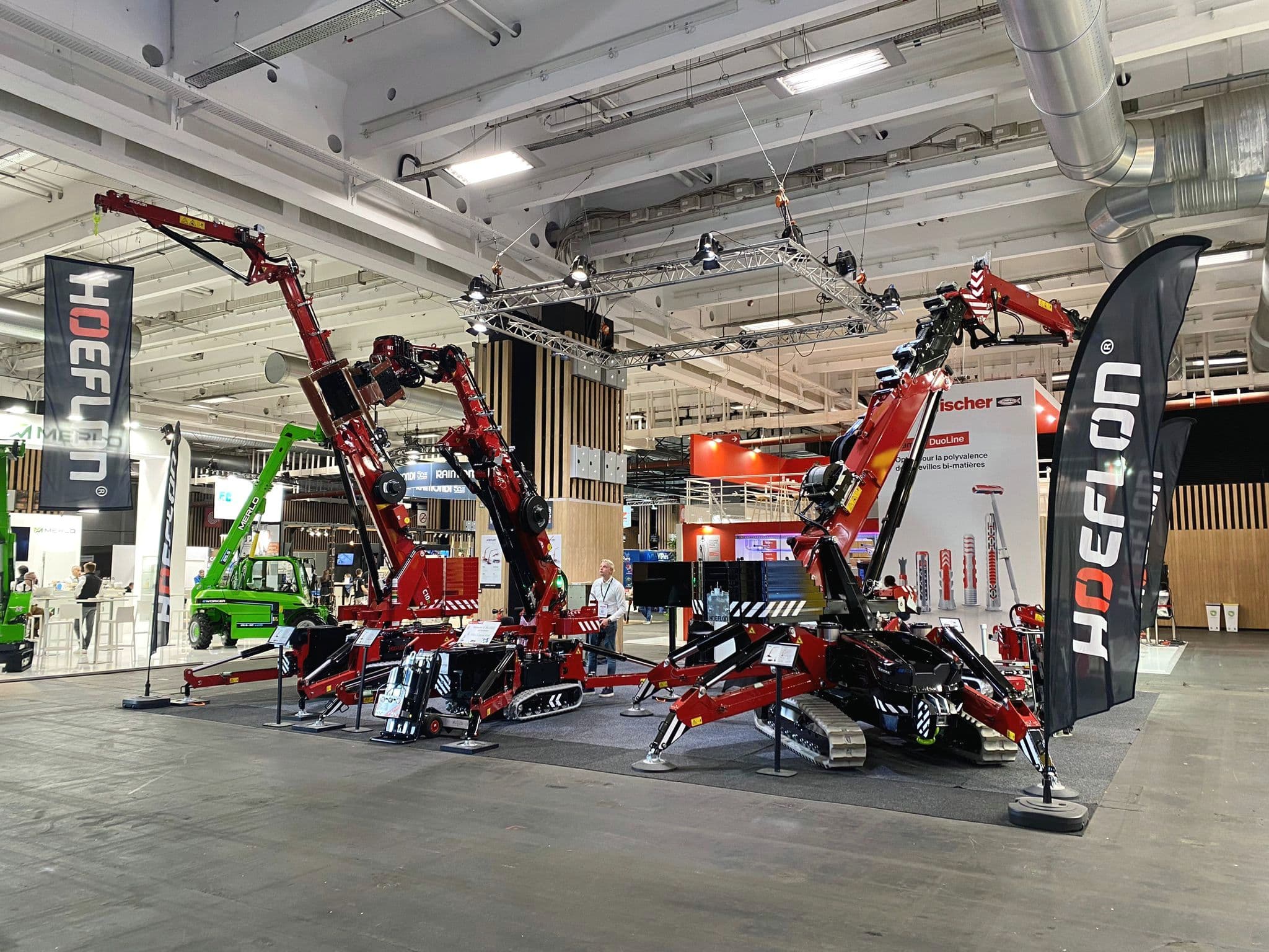 Hoeflon cranes at a trade show booth during Batimat 2024.