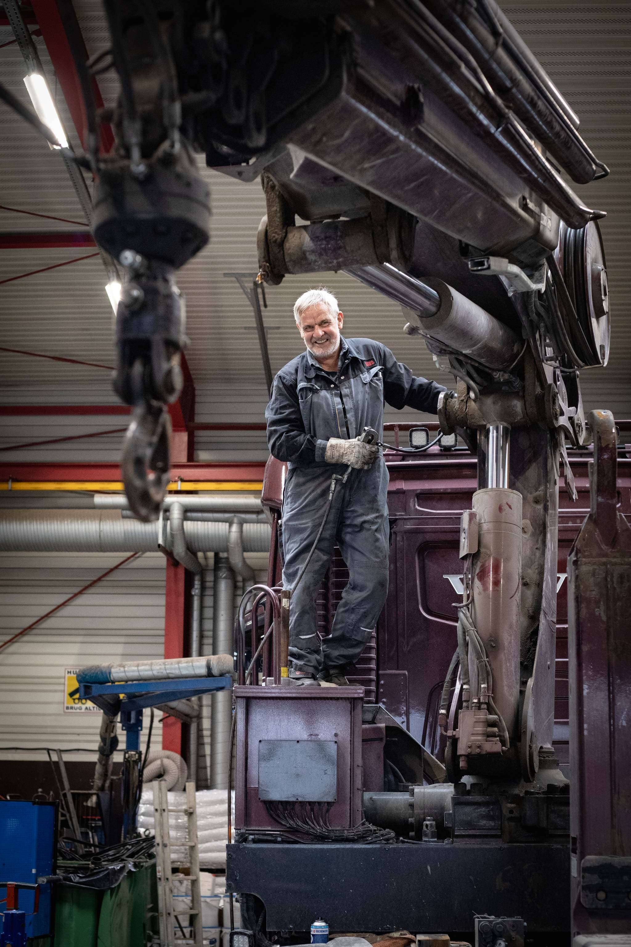 Mechanic working on a crane in a workshop.