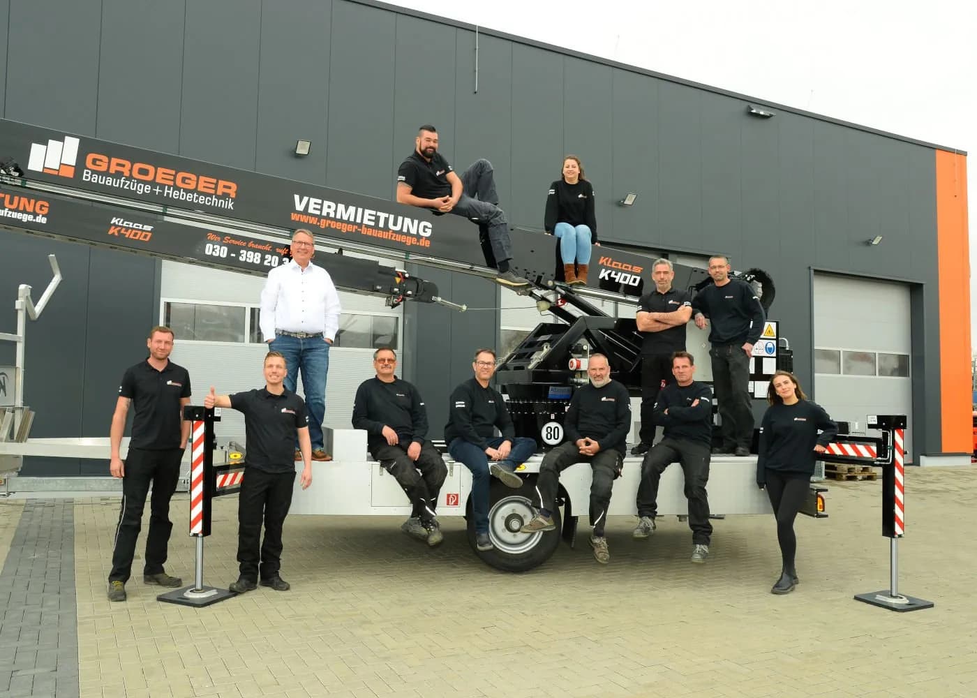 Groeger Bauaufzüge team photo with crane in the background.