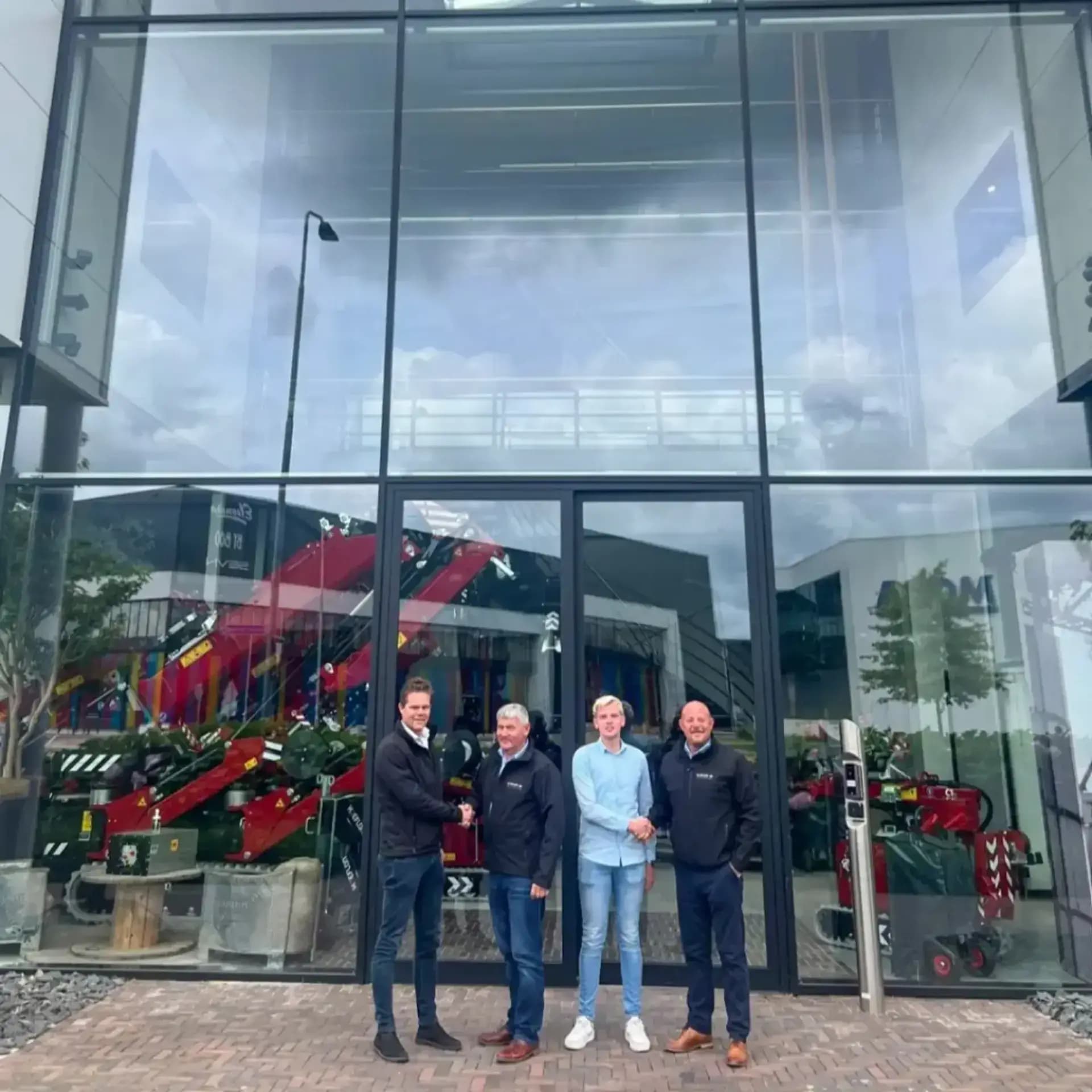 Mensen voor een pand die elkaar de hand schudden